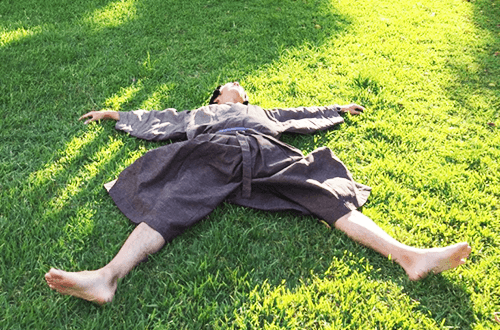 着物姿で芝生に大の字に寝転がる圓尾和紀さんの写真